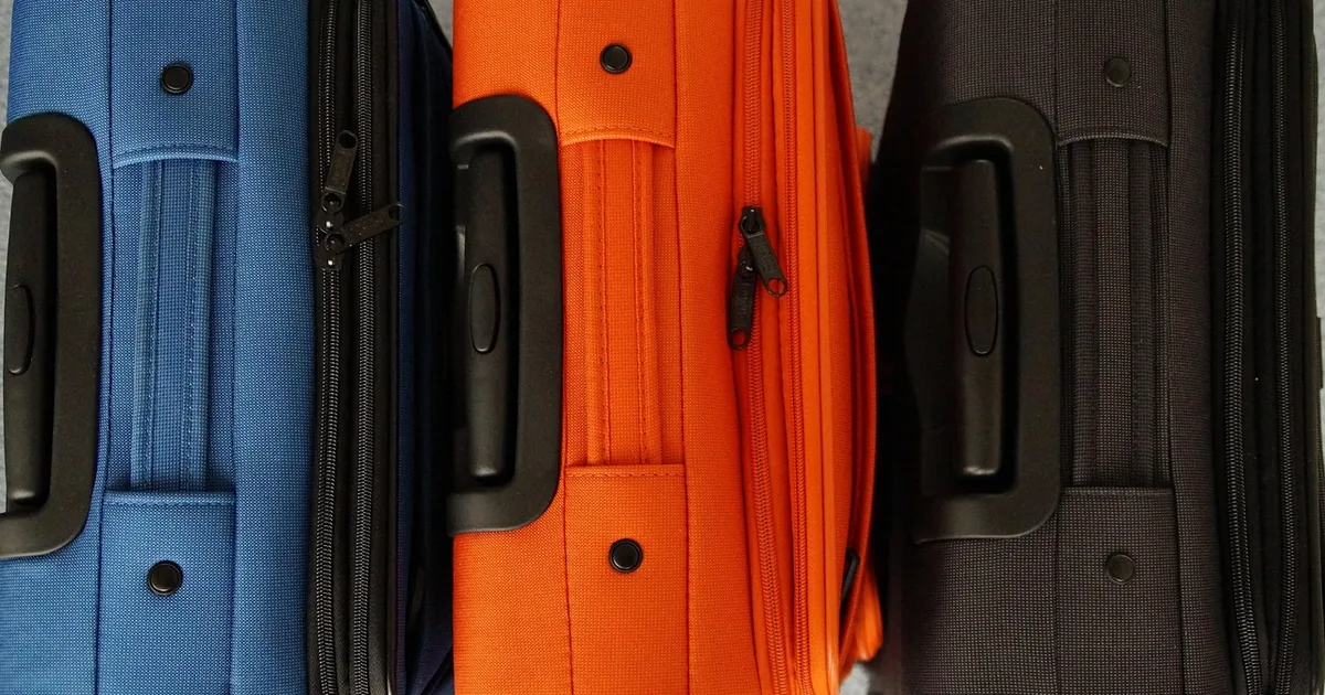 Trois valises colorées prêtes pour la rentrée en famille