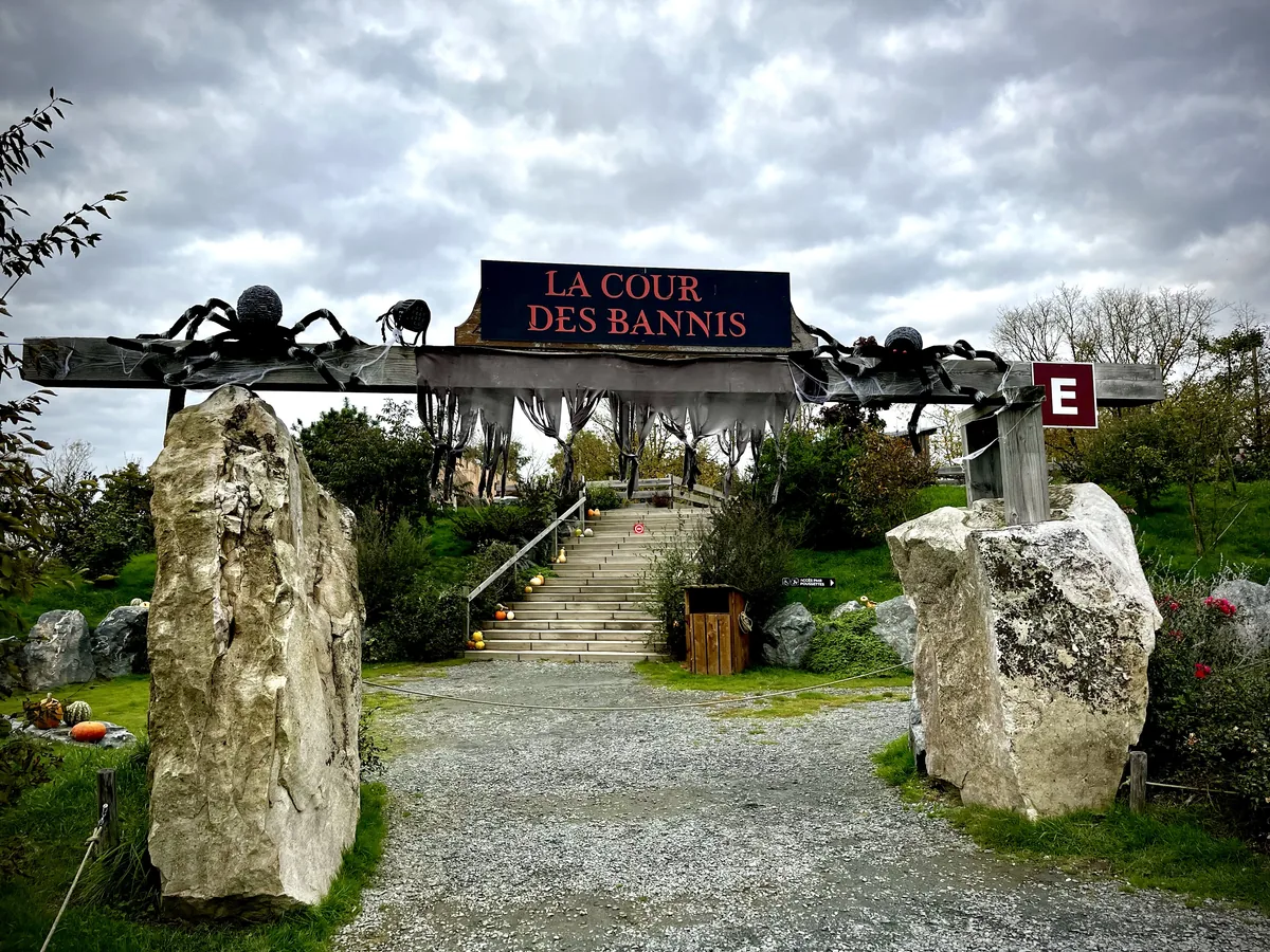Entrée de la Cour des Bannis à Légendia Parc, décorée pour Halloween avec araignées géantes