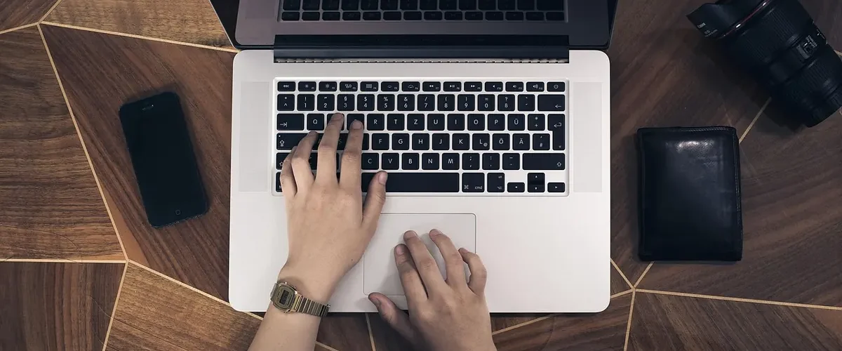 Rester en contact avec un enfant à l'étranger : bureau avec ordinateur, iPhone et appareil photo